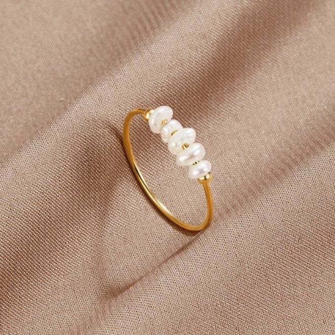 Bague perle d'eau douce élégante sur fond beige doux