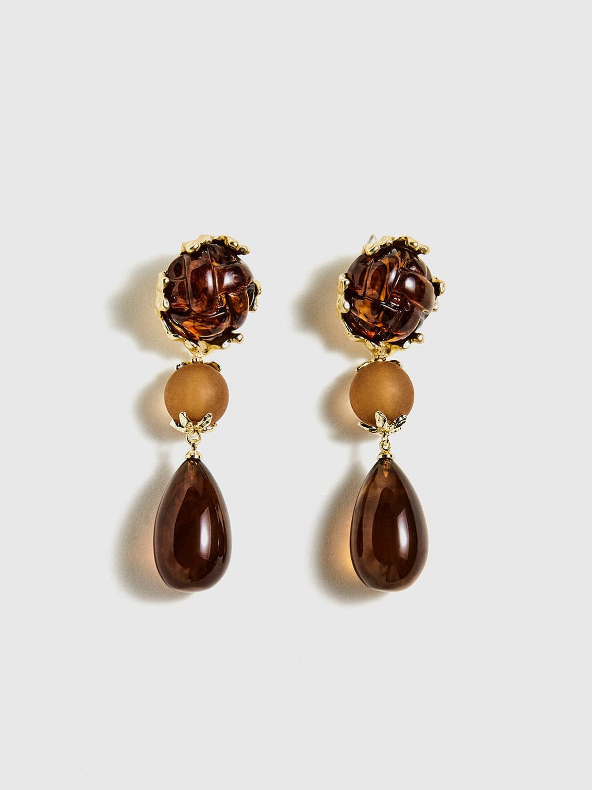 Boucles d'oreilles géométriques ambrées vue face soleil