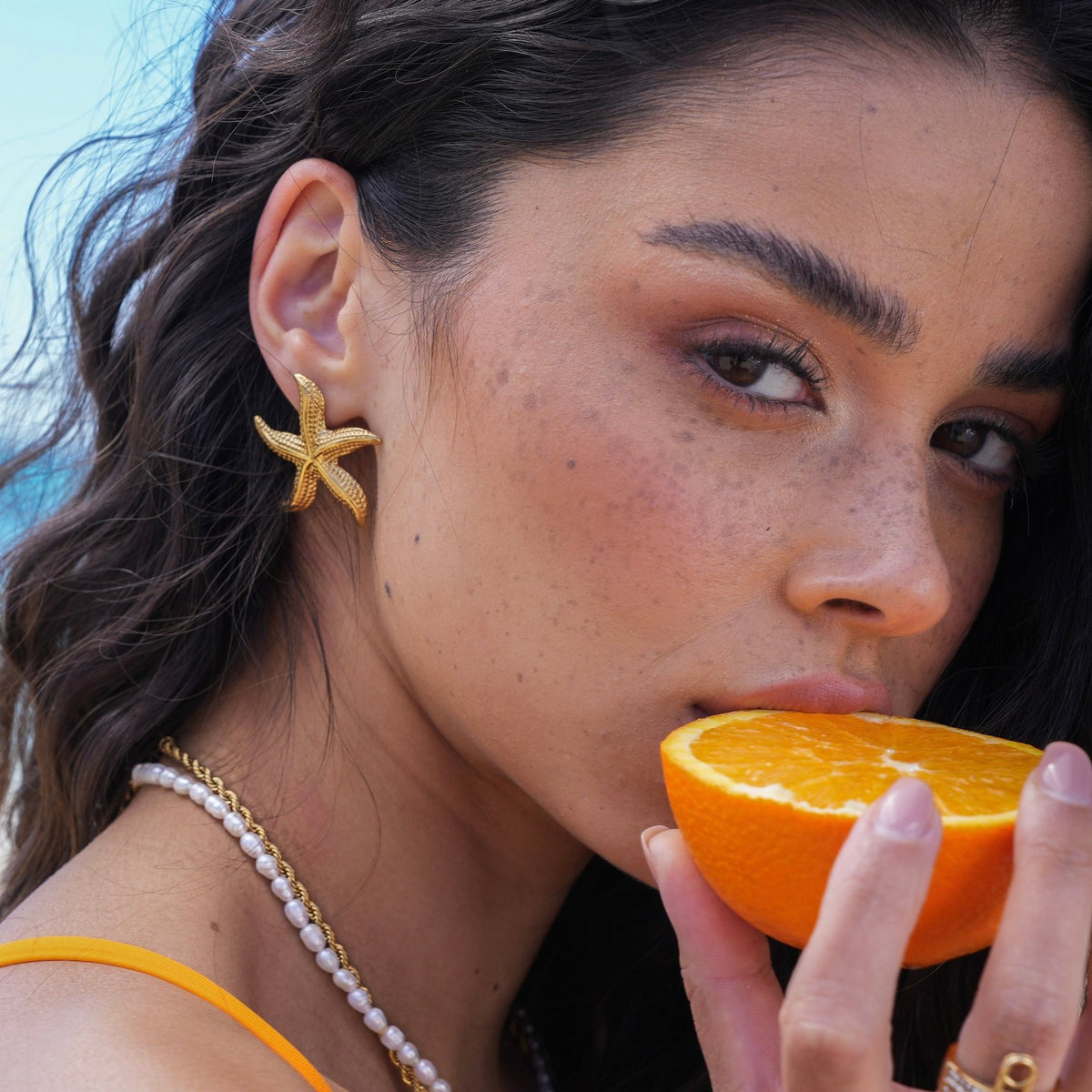 Boucles d'oreilles étoile de mer dorées portées soleil