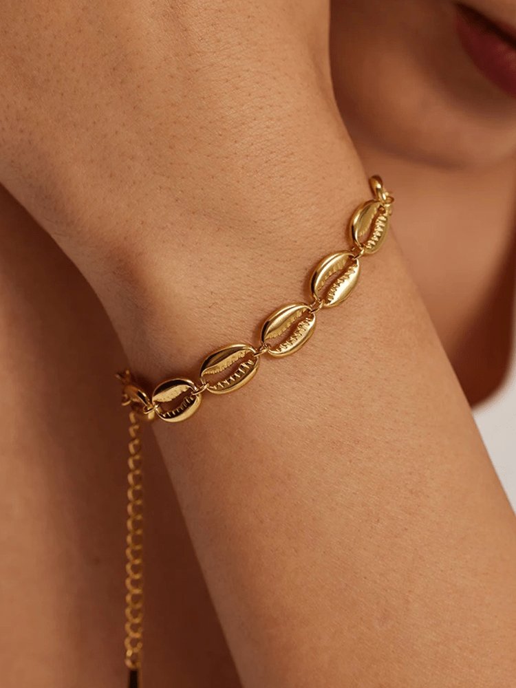 Bracelet coquillages doré sur poignet soleil