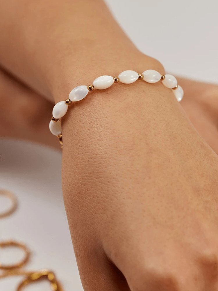 Bracelet coquillages dorés sur poignet élégant harmonie