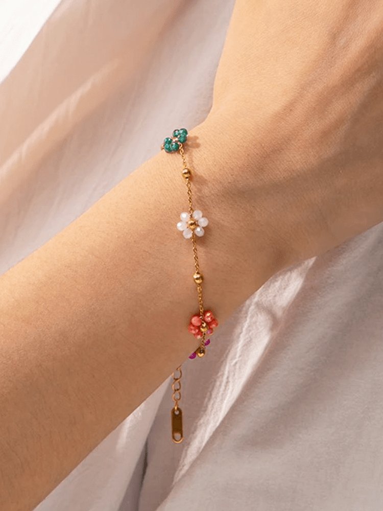 Bracelet fleurs colorées sur poignet délicat papillon