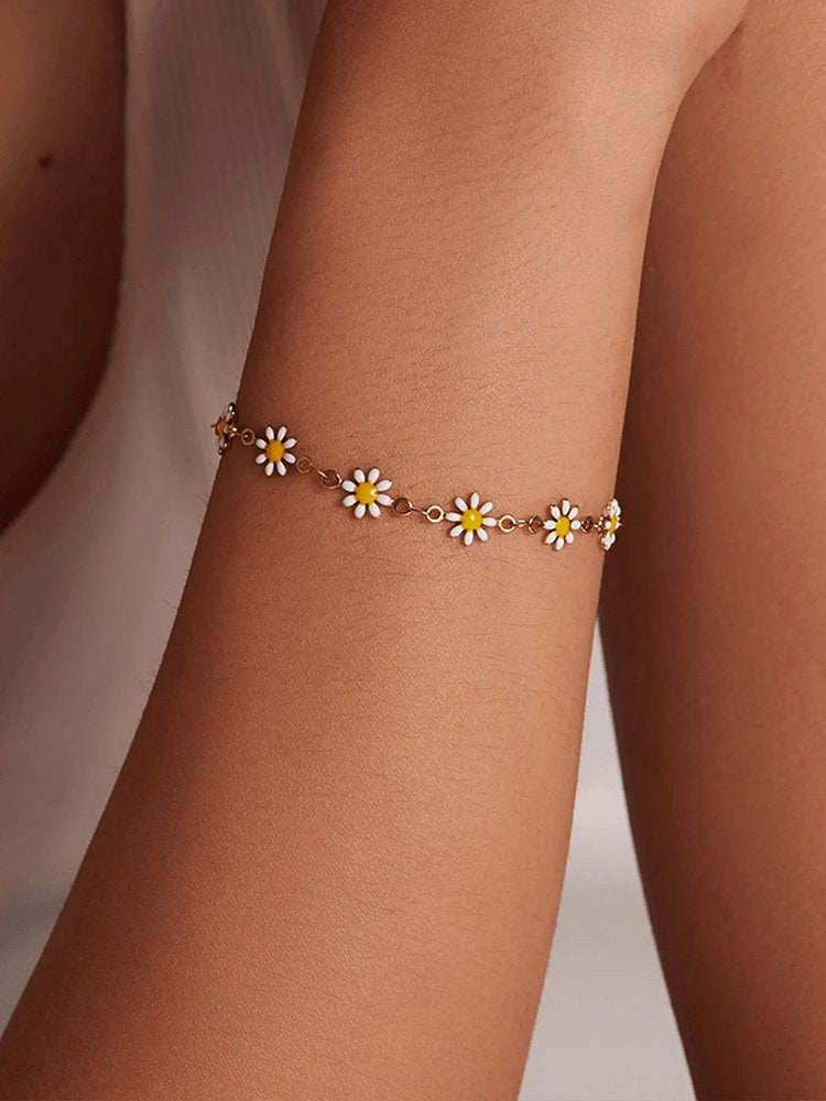 Bracelet marguerite doré porté au poignet soleil