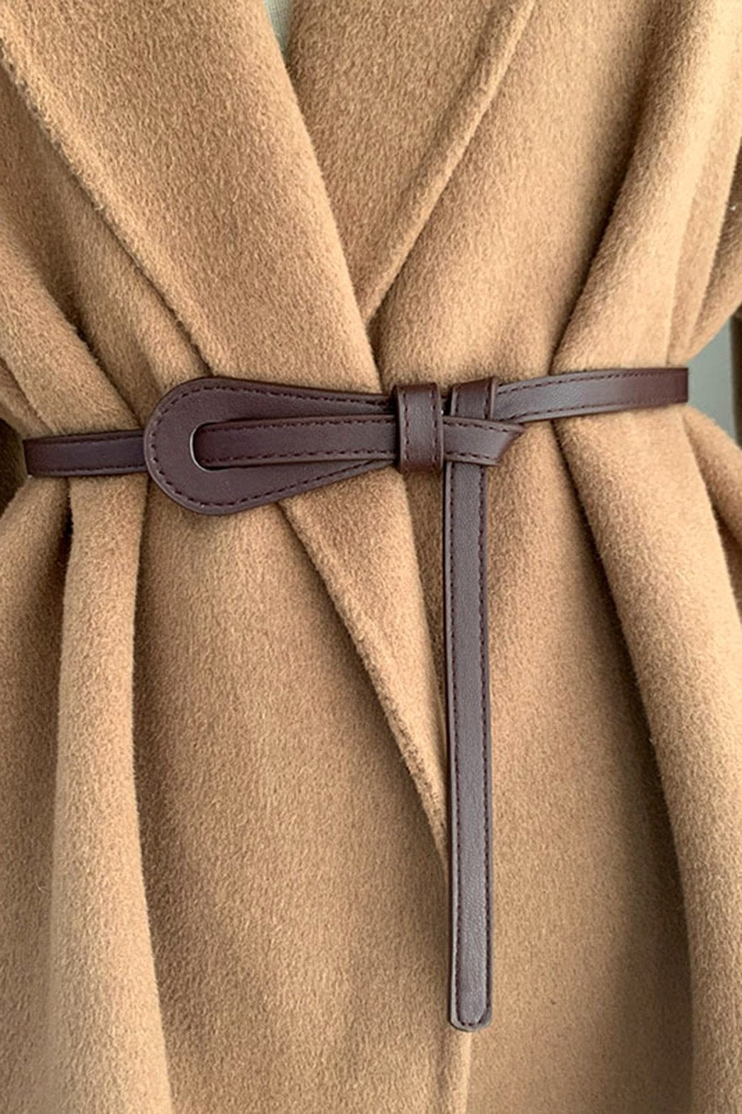Ceinture fine marron en simili cuir sur manteau beige douceur