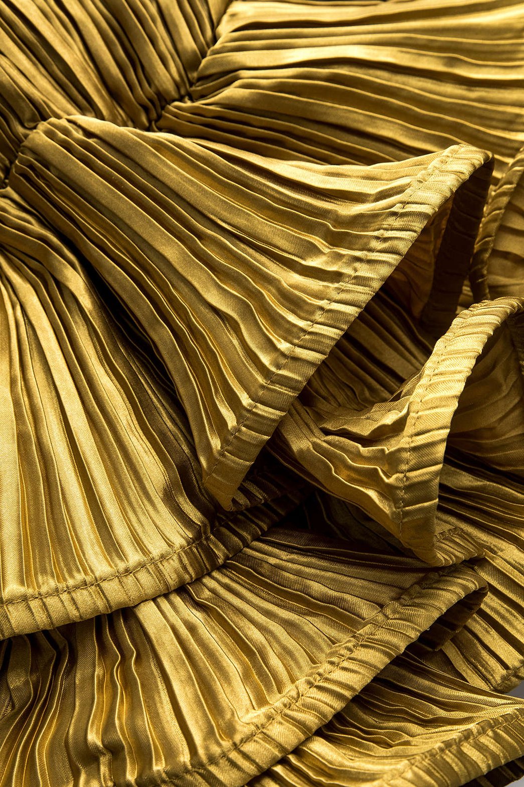 Vue de profil chemise plissée dorée cristal