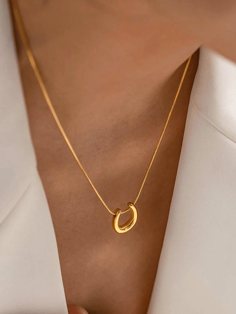 Collier fer à cheval doré porté élégamment soleil
