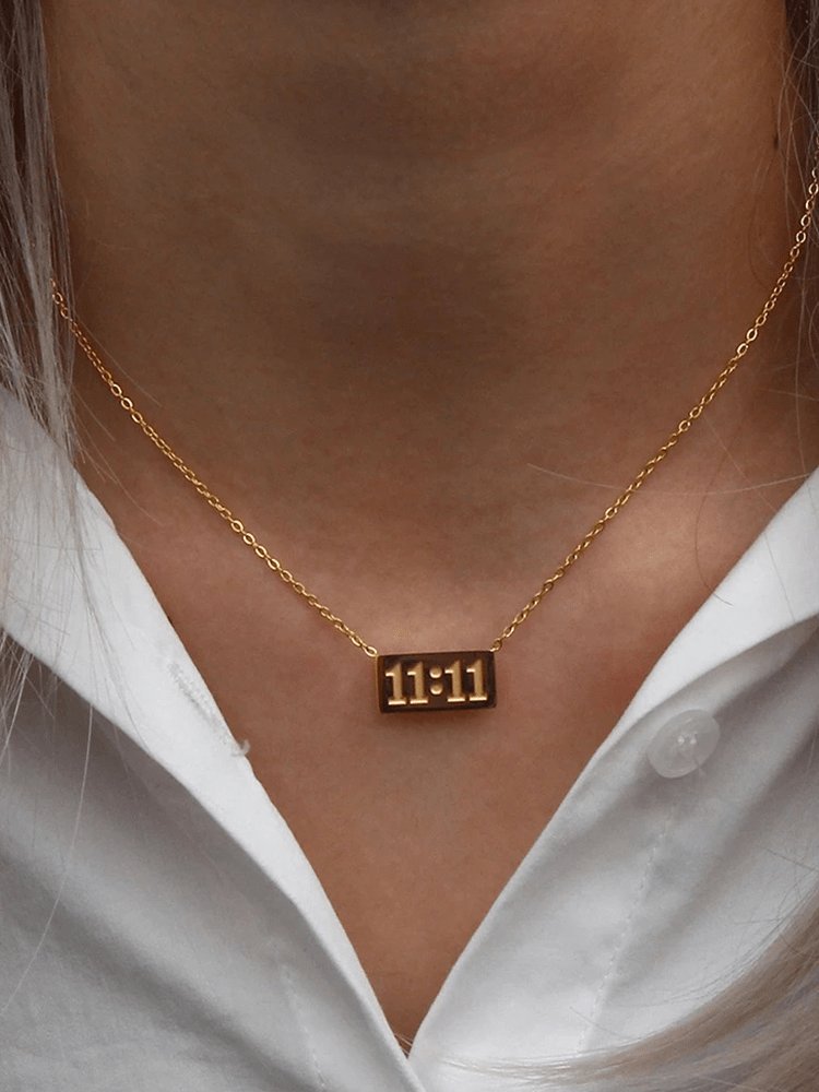 Collier doré 11:11 porté élégamment soleil