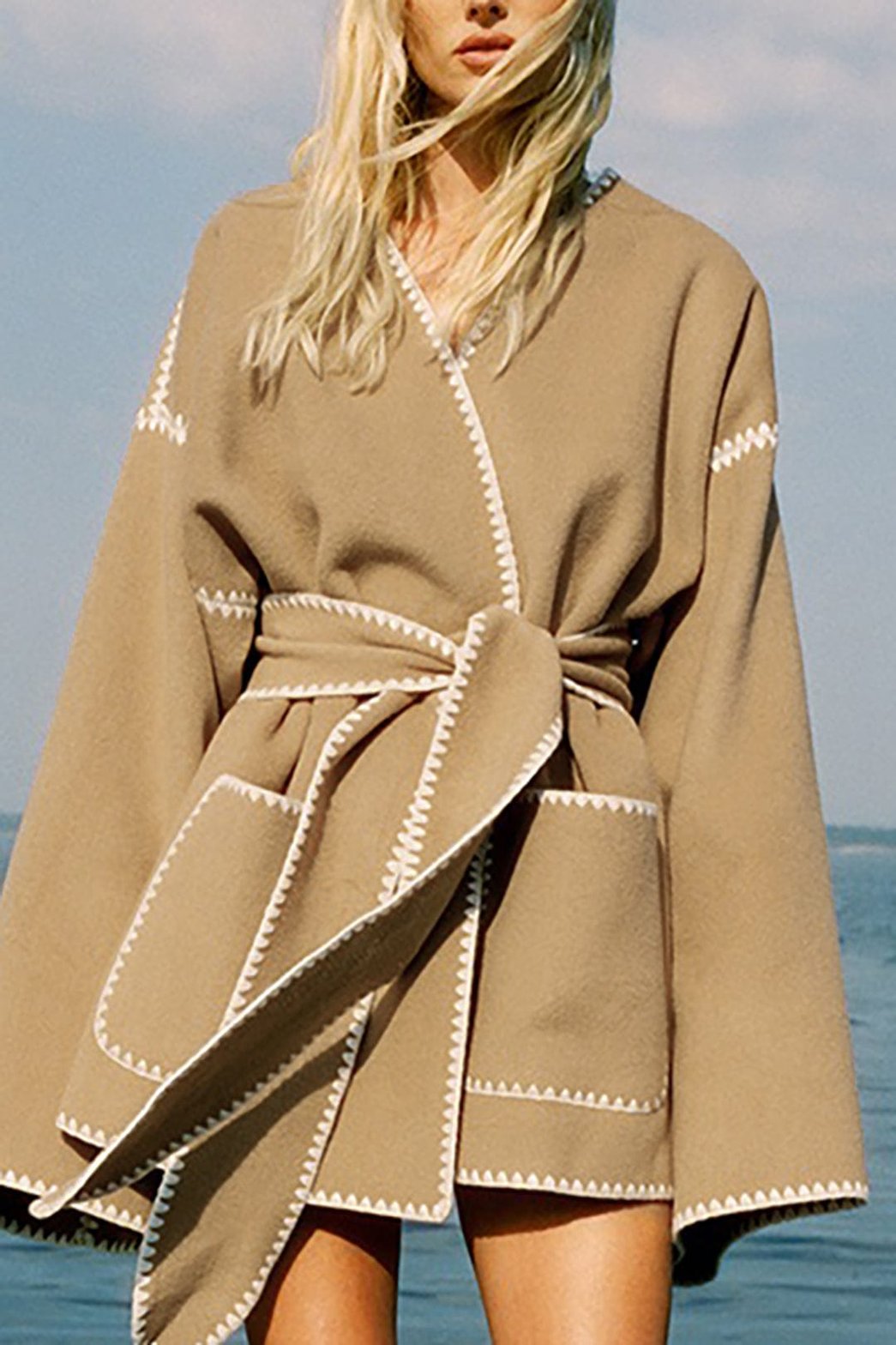 Manteau beige ceinturé avec surpiqûres décoratives soleil