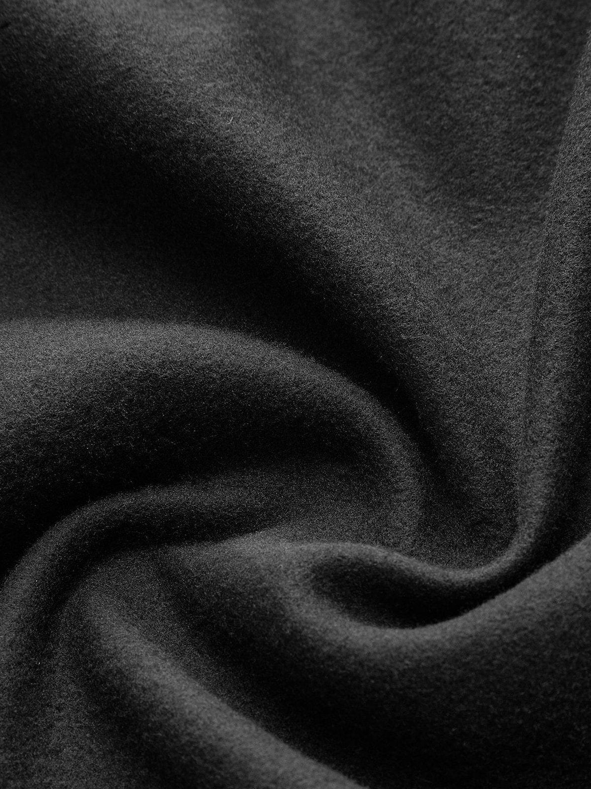 Détail des bordures contrastées du manteau tweed raffinement