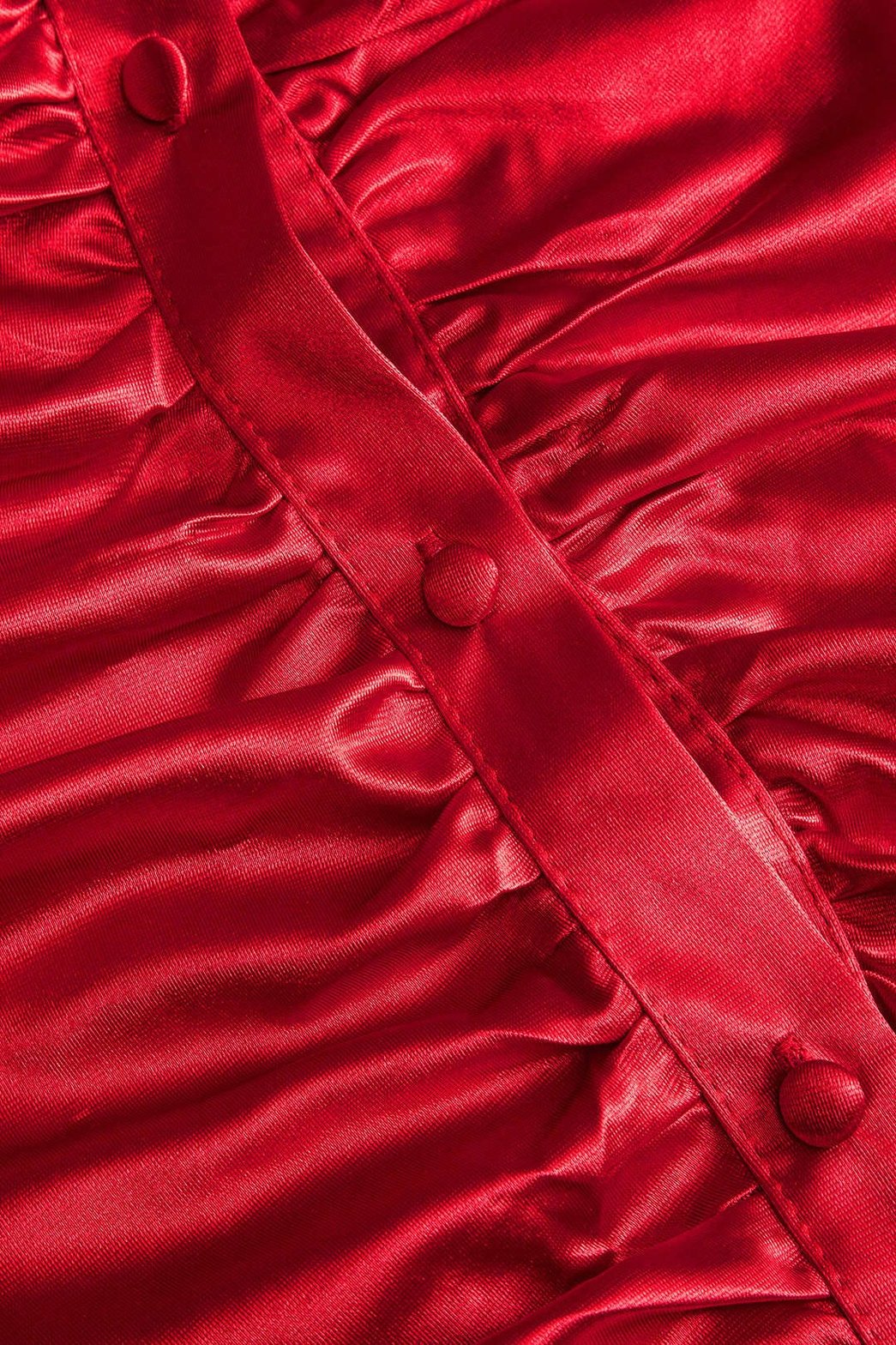 Détail des fronces sur robe satinée rouge étoile