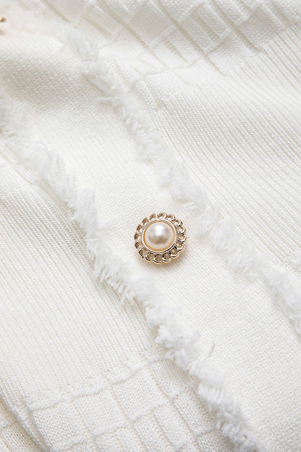 Détail des boutons robe tricot blanche - Élégance
