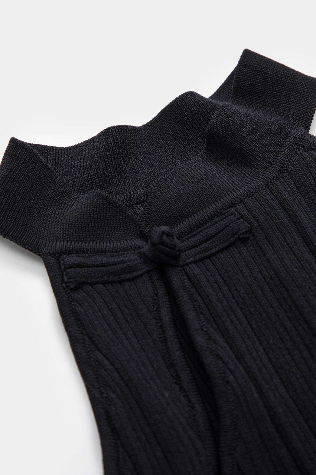 Top asymétrique noir côtelé vue de profil étoile