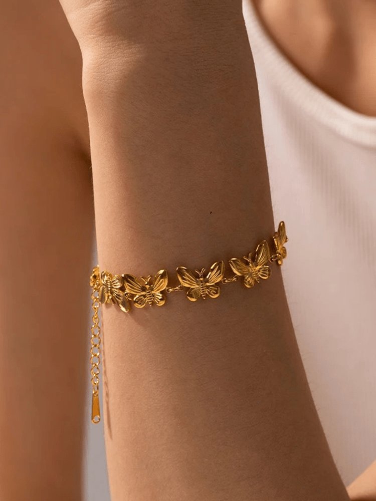 Bracelet papillon doré porté au poignet harmonie