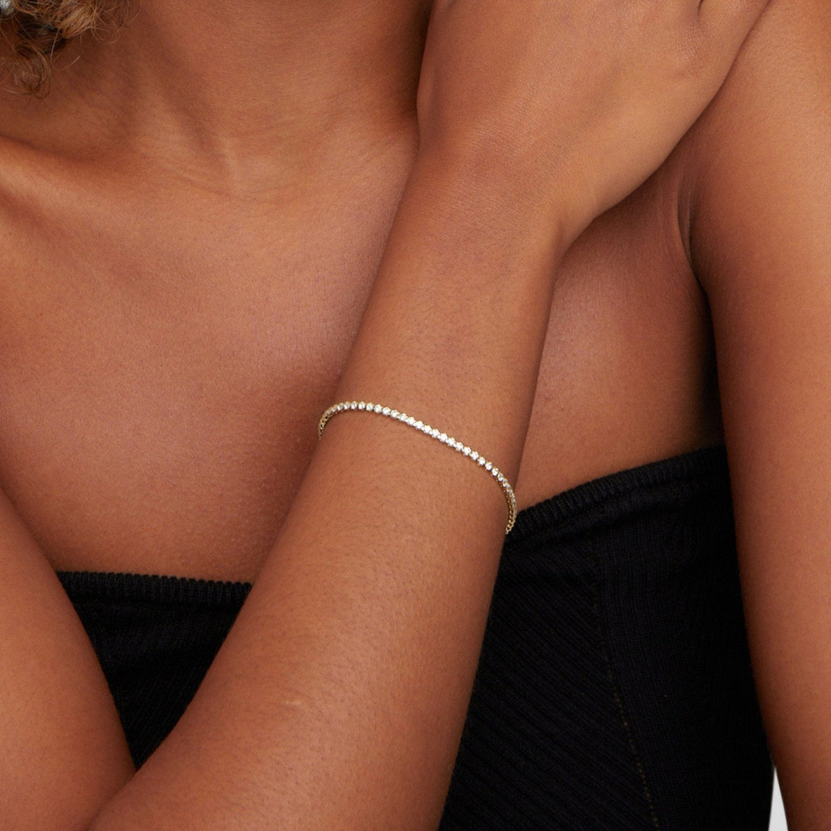 Bracelet tennis doré porté au poignet soleil
