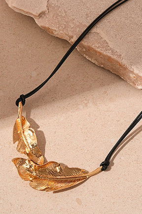 Détail pendentif feuille dorée métallique vent
