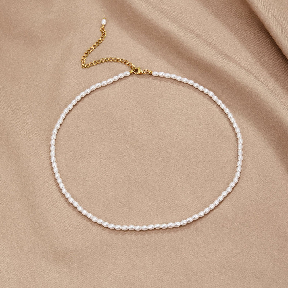 Collier de perles délicates sur fond beige doux