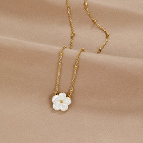 Collier fleur de nacre sur fond beige doux