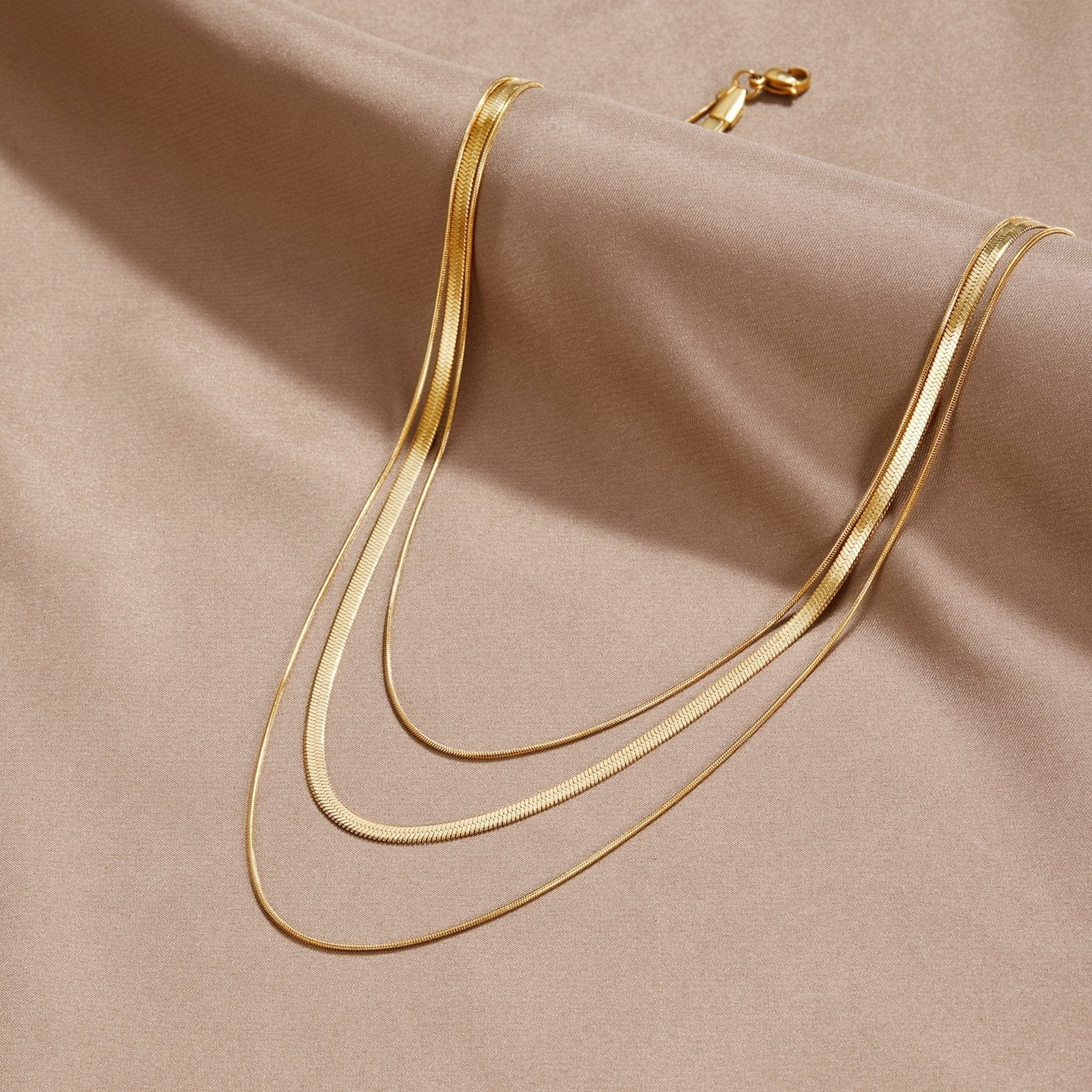 Collier multi-rangs doré élégant sur fond satin soleil