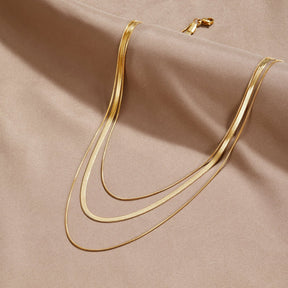 Collier multi-rangs doré élégant sur fond satin soleil