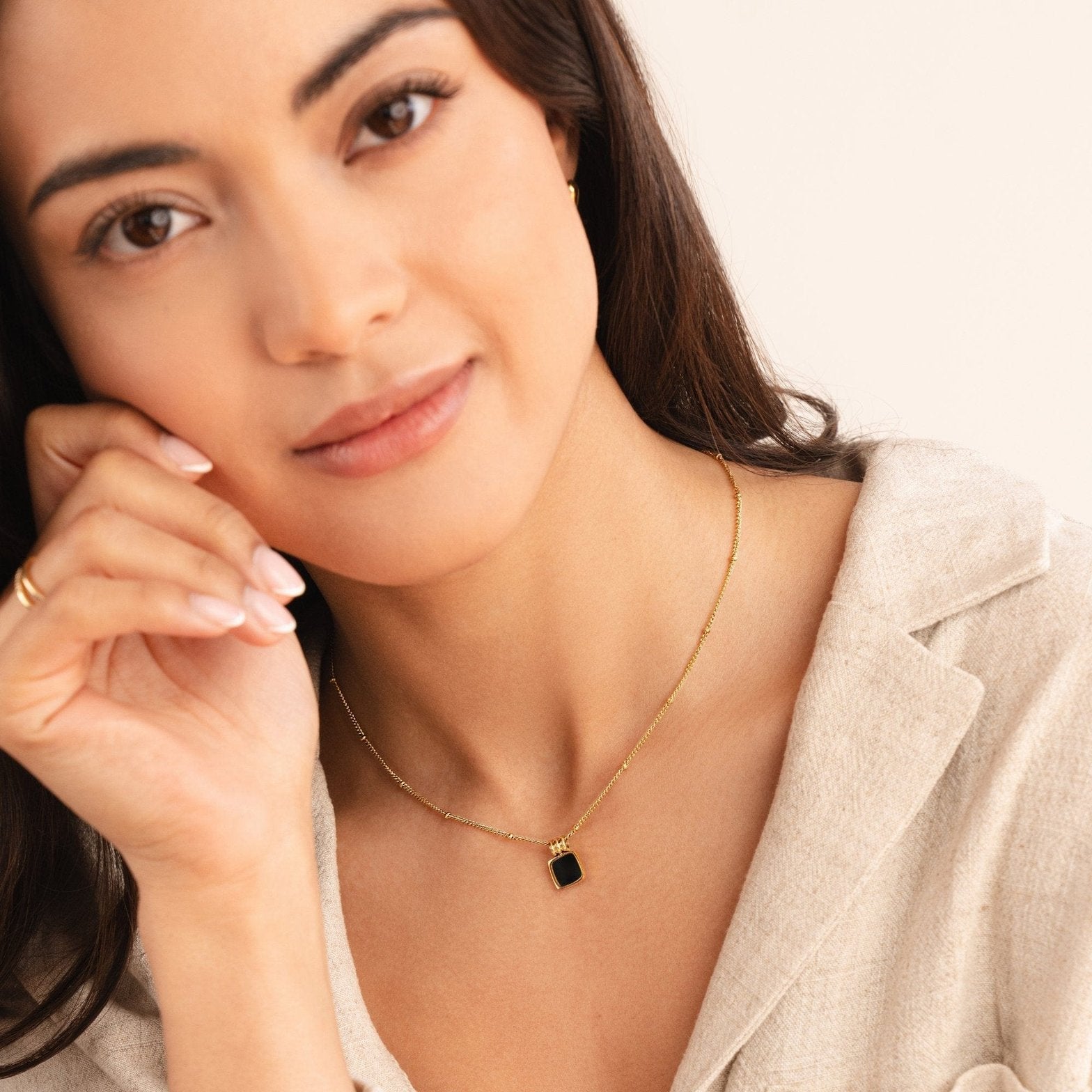 Collier pendentif noir sur fond beige délicat