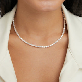 Détail du collier de perles avec chaîne dorée délicate
