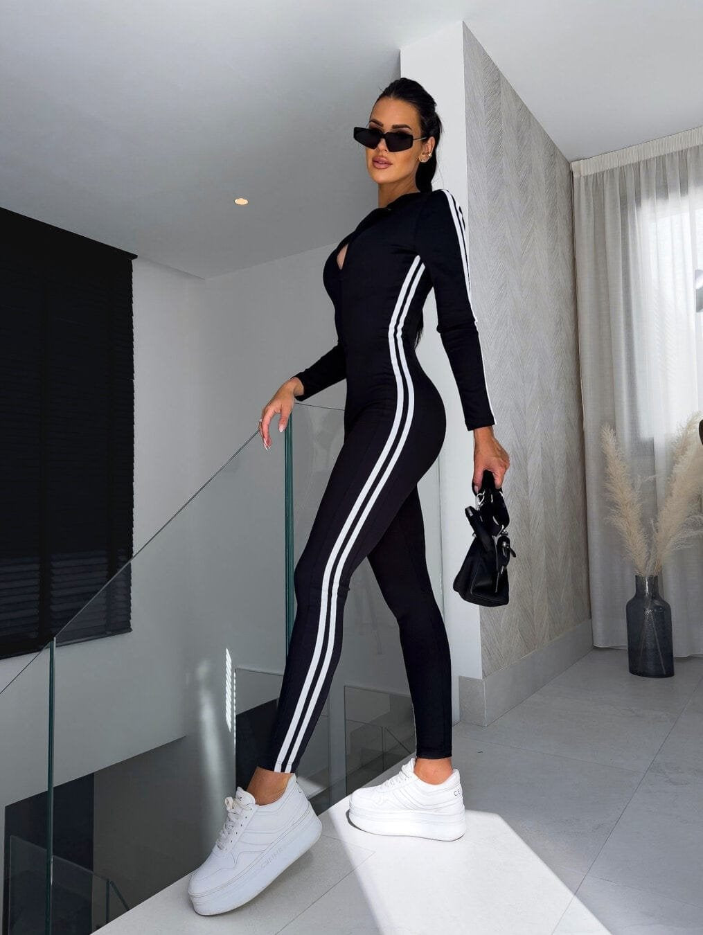 Combinaison sport chic noire avec bandes latérales blanches velours