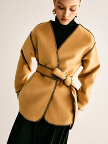 Manteau élégant avec bordure contrastée vue de face serein