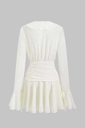 Robe mini blanche à volants vue de dos soleil