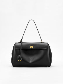 Sac à main noir élégant en cuir synthétique vue avant soleil