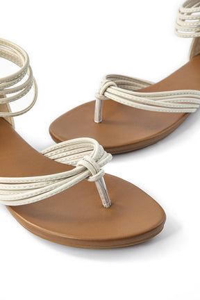 Détail des lanières des sandales plates blanc lune