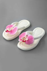 Tongs blanches avec orchidée rose soleil