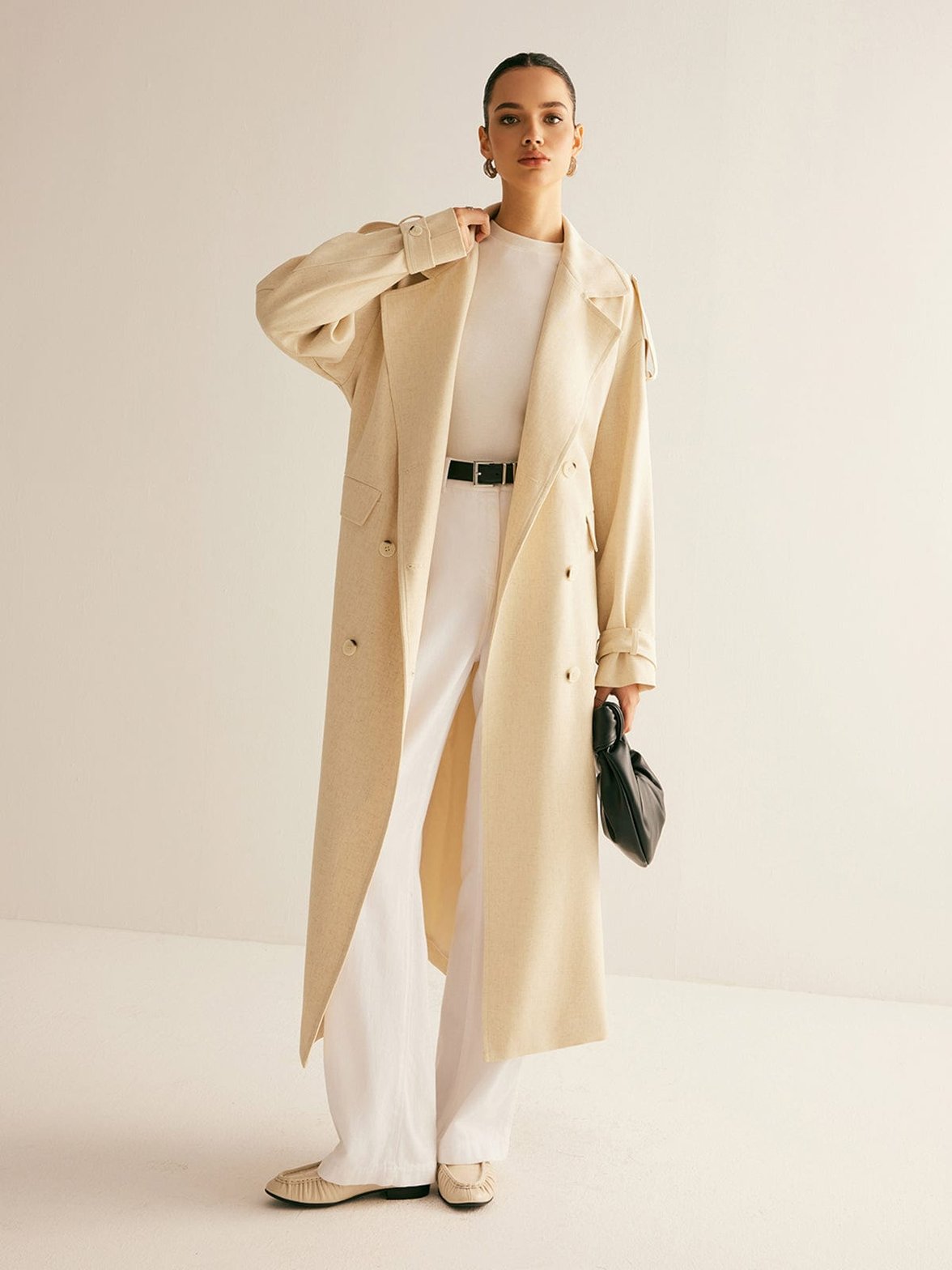 Trench beige élégant porté vue de face serein