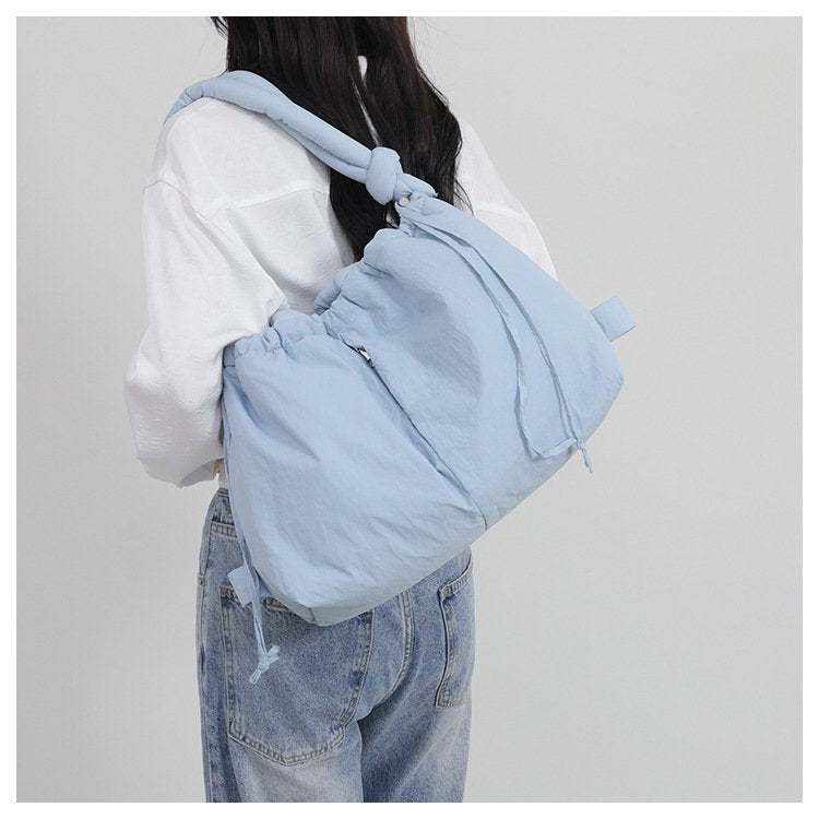 Sac à dos bleu ciel doux jolieandjuliette porté par femme en jean et chemise blanche