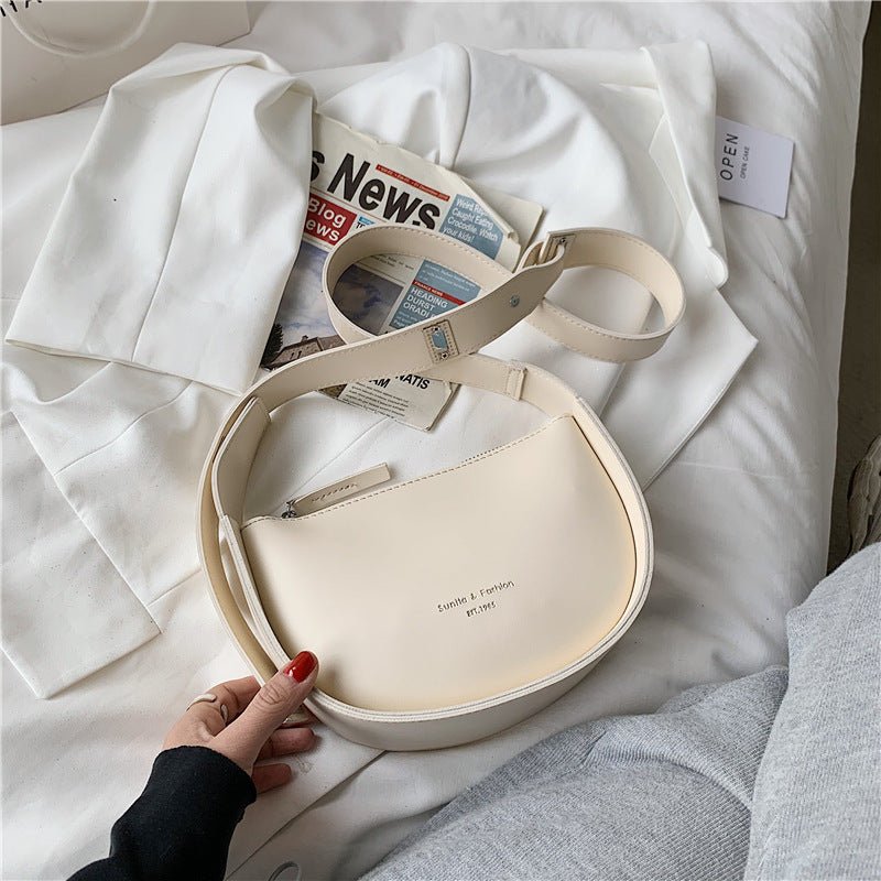 Sac bandoulière blanc crème jolieandjuliette élégant minimaliste sur lit avec journal