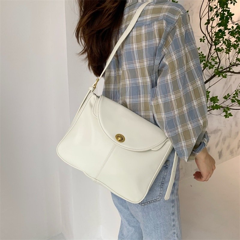 Sac bandoulière blanc élégant jolieandjuliette porté avec chemise carreaux et jean