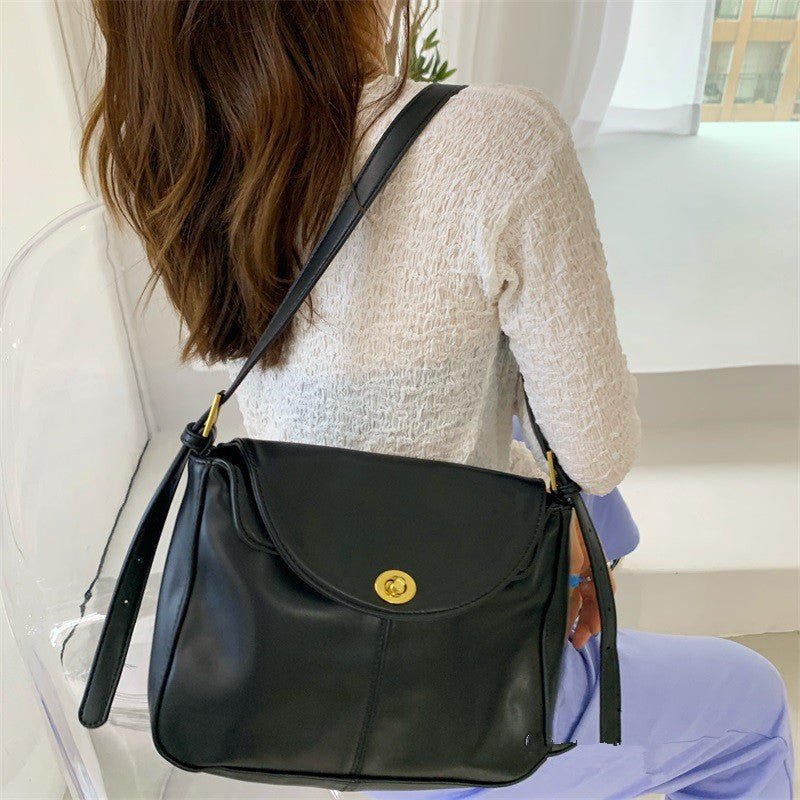 Sac bandoulière noir classique jolieandjuliette porté par femme en pull blanc