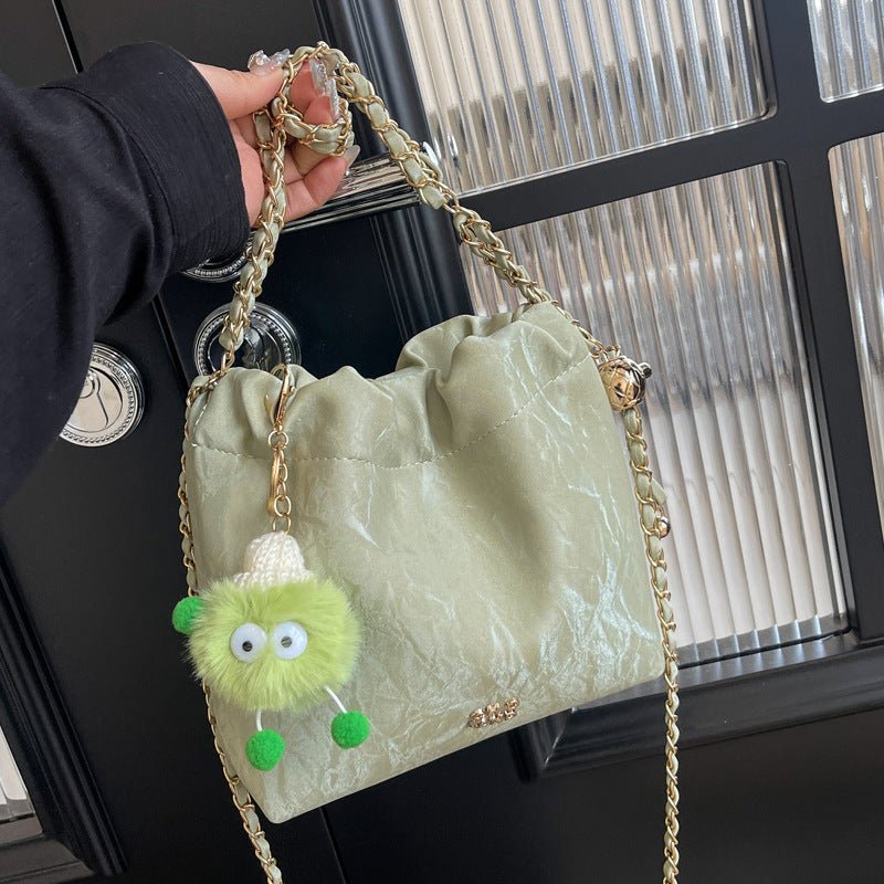 Sac à main vert pastel jolieandjuliette avec chaîne dorée et charm monstre vert