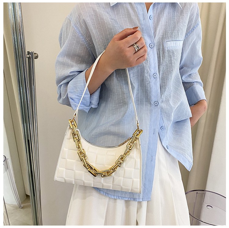 Sac à main blanc jolieandjuliette avec chaîne dorée, porté avec chemise bleue rayée