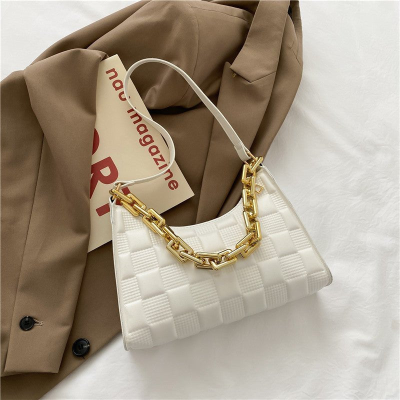 Sac à main blanc matelassé jolieandjuliette avec chaîne dorée sur veste beige