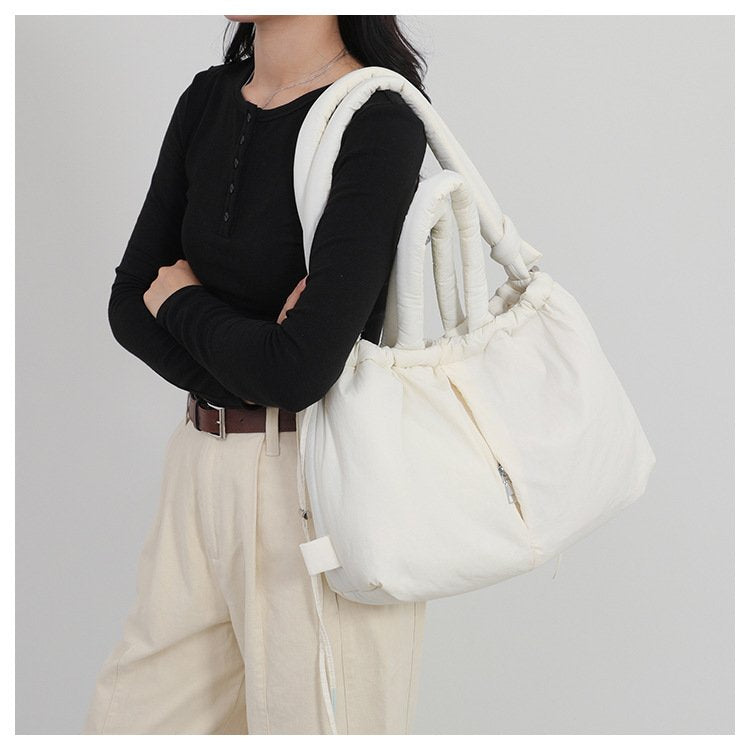 Sac fourre-tout blanc jolieandjuliette porté avec tenue élégante noire et beige