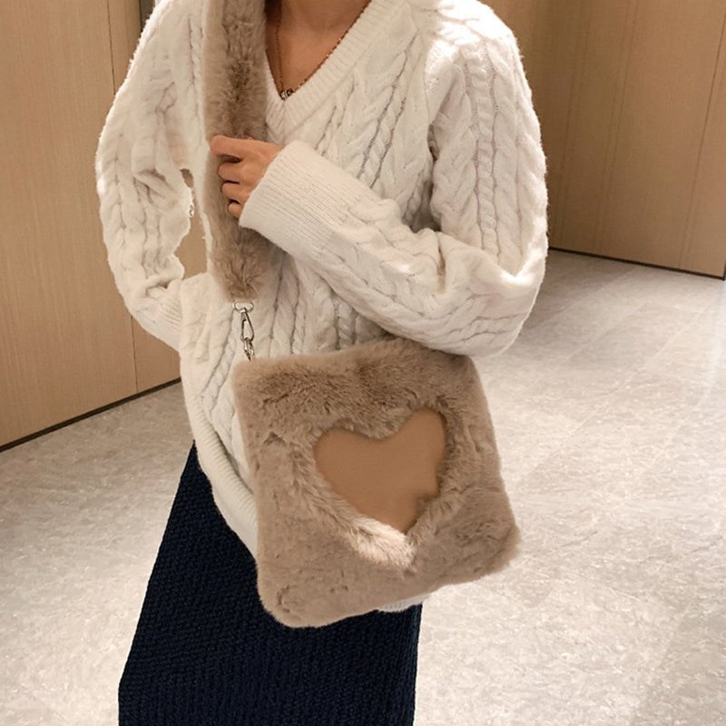 Sac fourrure beige jolieandjuliette avec découpe cœur, porté avec pull blanc tressé