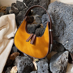 Sac hobo jaune moutarde jolieandjuliette en cuir sur rochers gris, style bohème chic