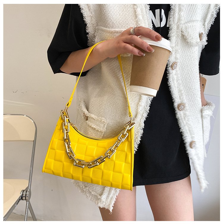 Sac à main jaune vif jolieandjuliette avec chaîne dorée, texture carrée, porté avec cardigan blanc