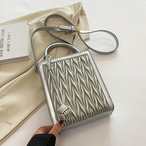 Sac à main argenté matelassé jolieandjuliette avec bandoulière élégante et design tressé