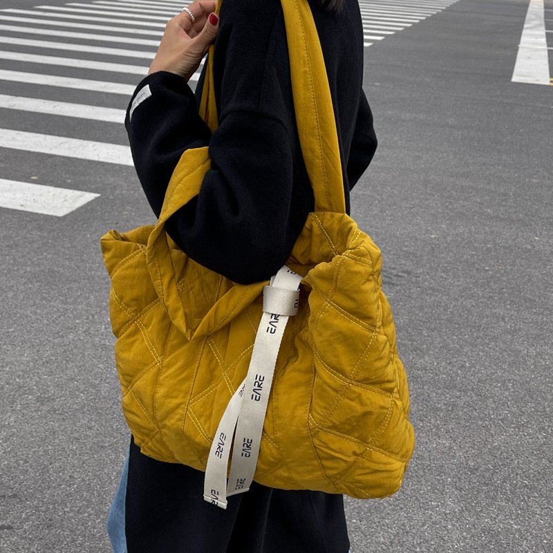 Sac matelassé jaune jolieandjuliette tendance urbain avec bandoulière sur passage piéton