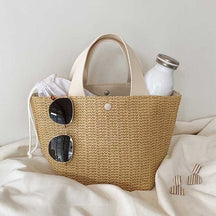 Sac de plage en paille beige jolieandjuliette avec lunettes de soleil et bouteille