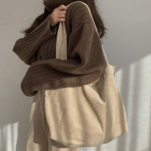 Sac fourre-tout en velours côtelé beige jolieandjuliette porté avec pull marron confortable